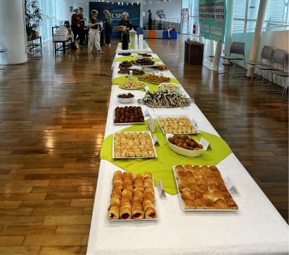 Mesa longa de coffee break em evento de extensão